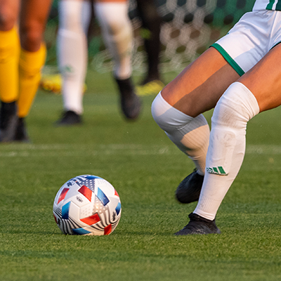 female player kicking a soccer ball